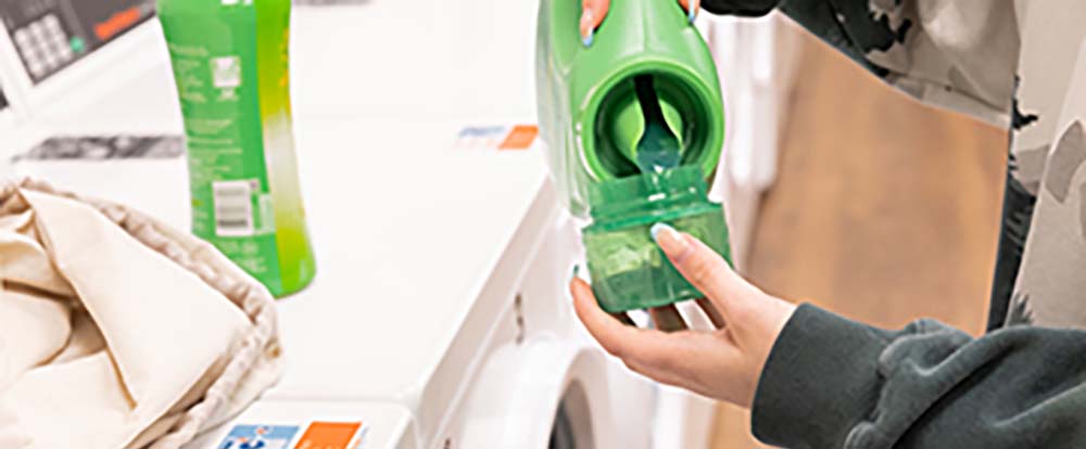 A laundry detergent cap being filled with detergent