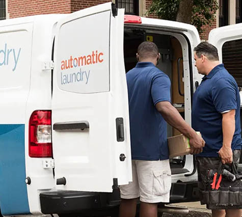 Two team members of Automatic Laundry outside of their service van
