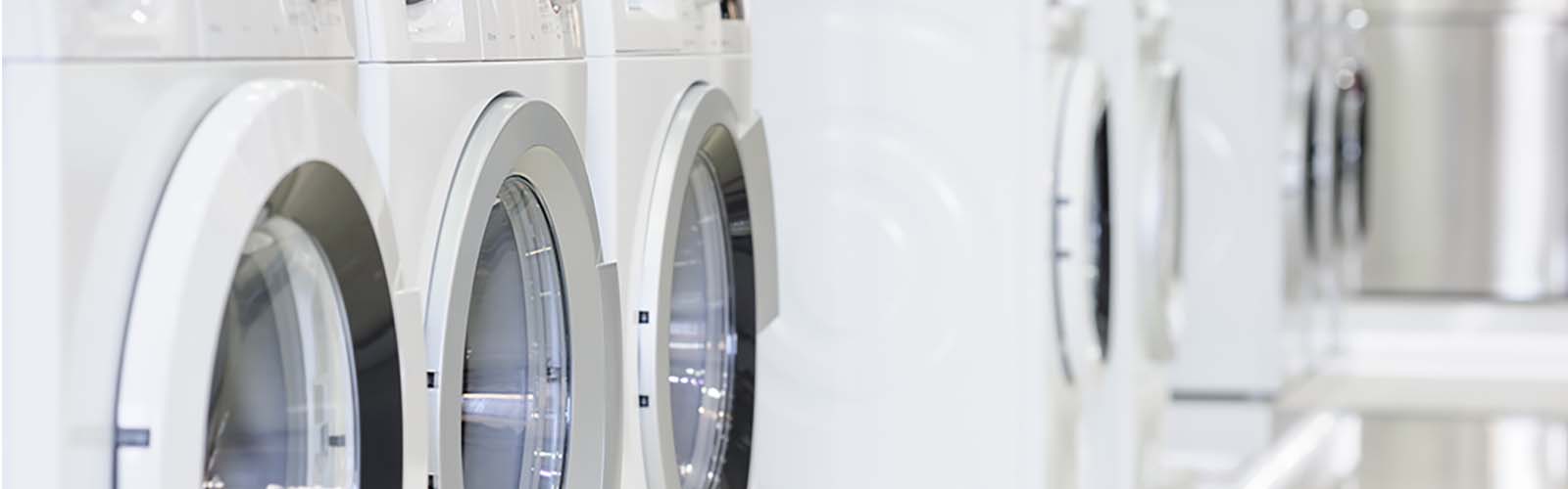 A row of white laundry machines seen close up