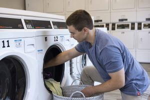 man getting laundry out of washing machine