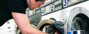 man getting laundry out of machine