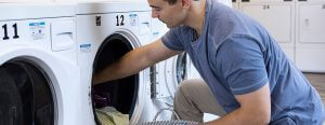 man getting his laundry out of washing machine